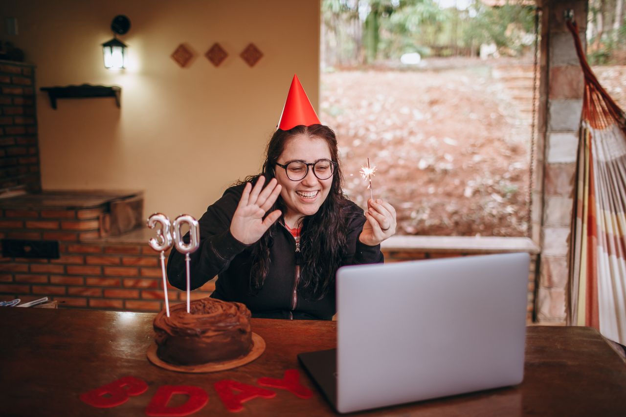services-03 Woman celebrating 30th birthday with a virtual party, cake, and candles.